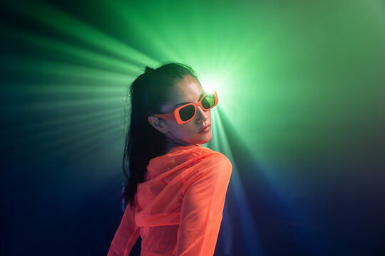 Latin woman urban dancer in neon light and sunglasses