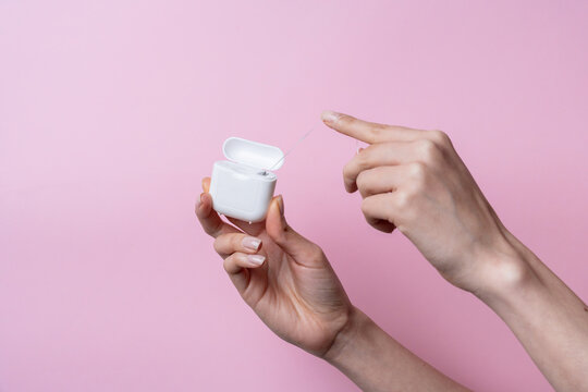 Caucasian woman hand flossing teeth with dental floss