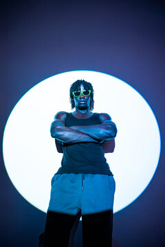 African man in neon sunglasses with circular studio light