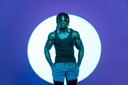 African man in sunglasses posing under glowing circle light