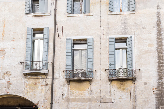 Weathered facade with shuttered windows in Treviso, Italy