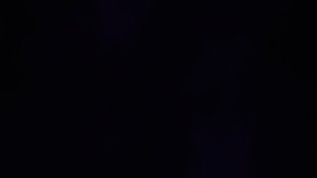 Ethereal 4K purple large black shadow smoke plume billowing with a radiant violet rim on a dark background, seamless loop motion graphic animation for cinematic atmospheric visual effects.