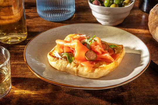 Rustic Mediterranean tapas of smoked salmon on bread with wine