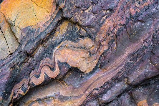 Abstract metamorphic rock texture with wavy mineral bands