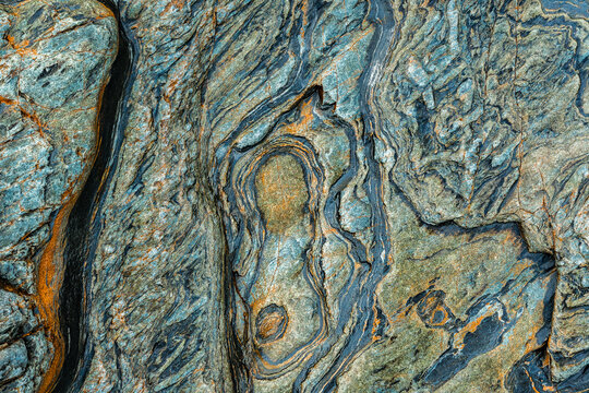 Abstract metamorphic rock texture with blue and rust veins