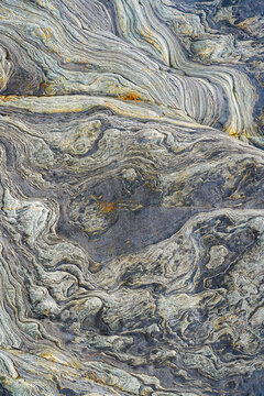 Abstract metamorphic rock texture with flowing stone layers