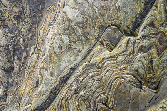 Abstract metamorphic rock texture with swirling stone layers