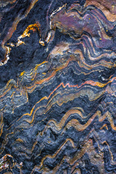 Abstract metamorphic rock texture with wavy mineral veins