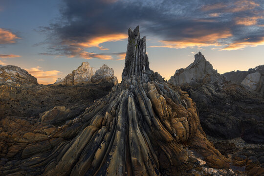 Dramatic Asturian rocky coast at sunset with dark clouds