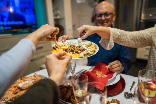 Family sharing appetizers and drinks at festive dinner table