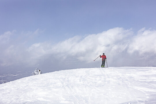 Splitboarder touring in Japan on snowy ridge in powder