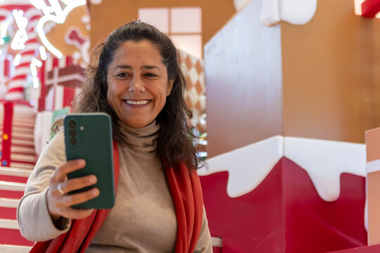 Smiling woman taking smartphone selfie in china mall decor
