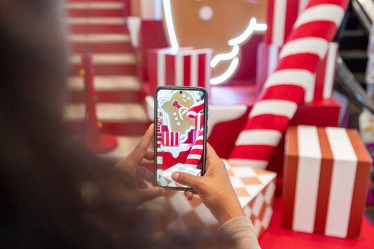 Person using smartphone to capture festive holiday d&eacute;cor
