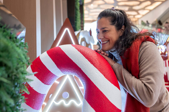 Smiling woman with candy cane Christmas decoration in china