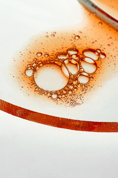 Abstract macro of amber oil bubbles on white surface