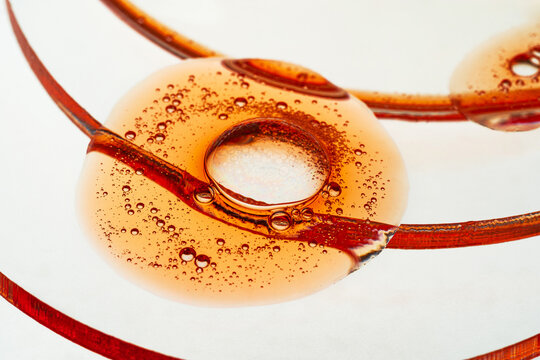 Abstract macro of amber liquid bubble with tiny droplets