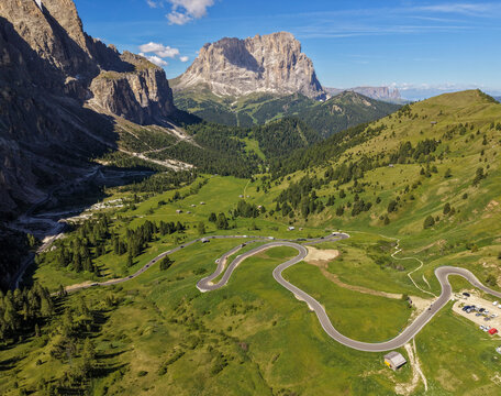 Winding alpine road through green Dolomites valley