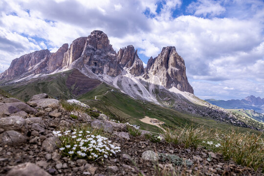 Dramatic Dolomites peaks above alpine meadow and clouds