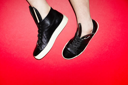 Black sneakers with bunny ears on red background