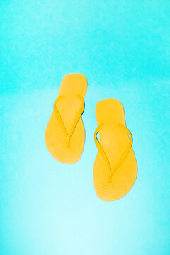 Yellow flip-flops on bright blue background