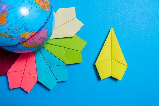 Global Travel Concept with Colorful Paper Planes and World Globe