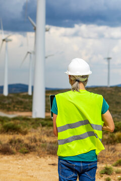 Renewable energy technician inspecting wind turbine farm