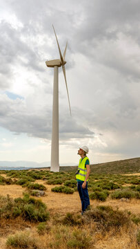 Technician and engineer inspecting wind turbine in desert