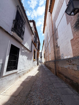 Narrow cobblestone alley in Cordoba old town, Spain