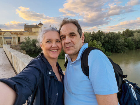 Couple taking a selfie on a bridge in Cordoba, Spain