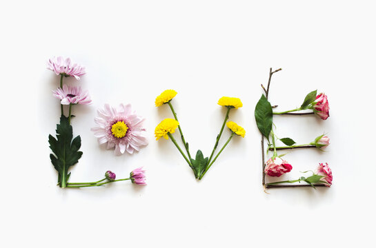Flower lettering LOVE flat lay with copy space on white