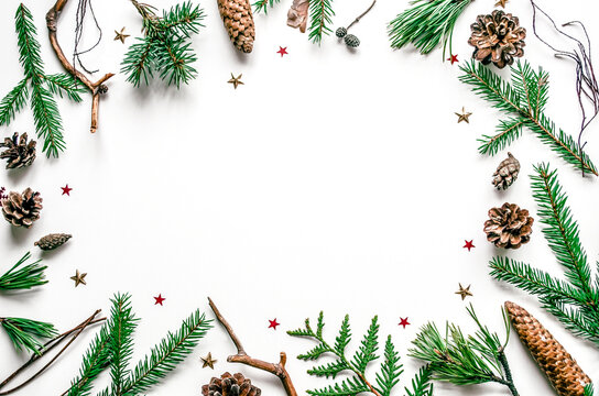 Christmas fir branch frame with cones and star confetti