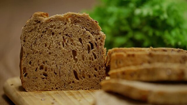Close-up of soft freshly baked bread sliced on a wooden board in a warm kitchen setting. The inviting food scene captures homemade baking, breakfast preparation, comfort food moments.