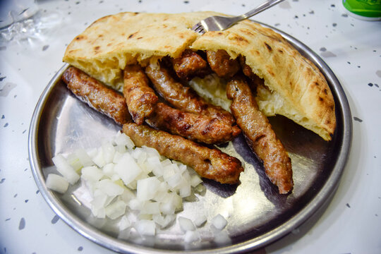 Traditional grilled sausages with pita and onions