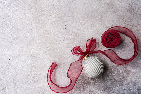 Minimalist grey Christmas background with ornament and ribbon