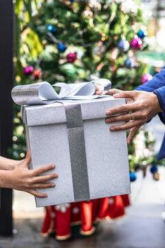 Exchanging gifts by a Christmas tree