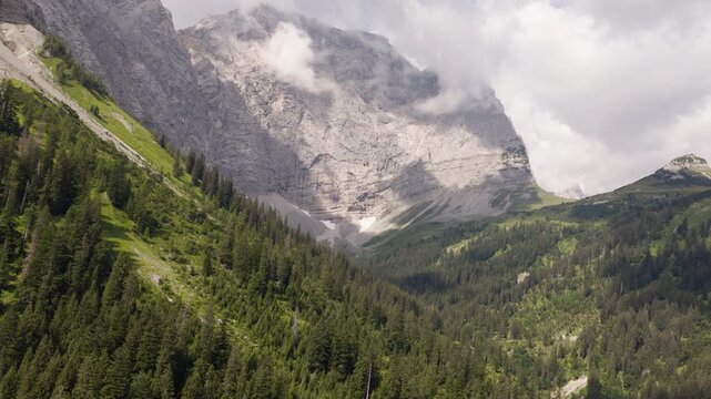 Cinematic drone flight toward sunlit limestone cliffs in the Karwendel Mountains near Eng Alm, Tyrol, Austria