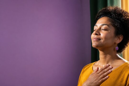 Mindfulness portrait of a woman in calm meditation with hand on heart