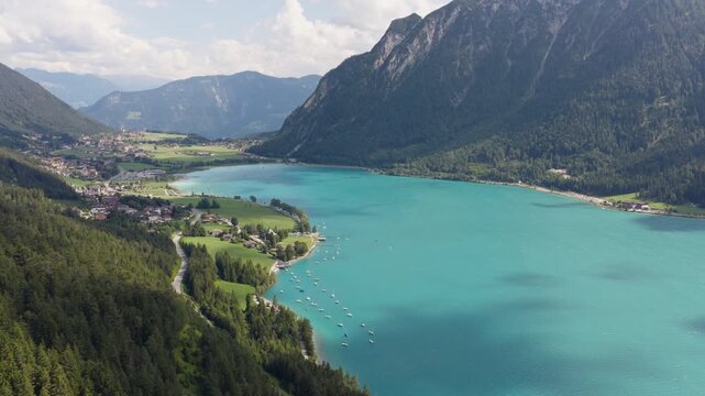 Drone view of turquoise Lake Achensee with marina and alpine village in the Austrian Alps