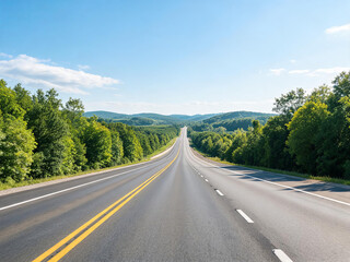 Fototapeta premium A long straight two-lane highway cuts through lush green forests and rolling hills under a clear bright blue sky.