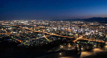 Fototapeta premium Stunning panoramic night view of Sapporo cityscape and observatory deck from Mount Moiwa in Hokkaido Japan