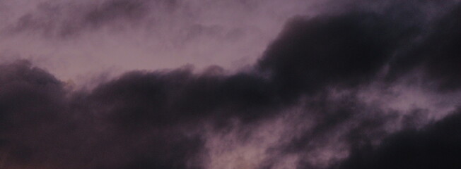 Obraz premium Dark stormy clouds filling the evening sky with dramatic purple and grey atmospheric weather texture