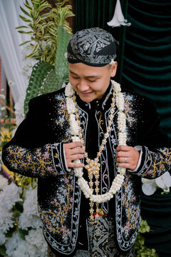 Happy Indonesian Javanese Groom in Royal Black Velvet Beskap with Gold Embroidery and Blangkon