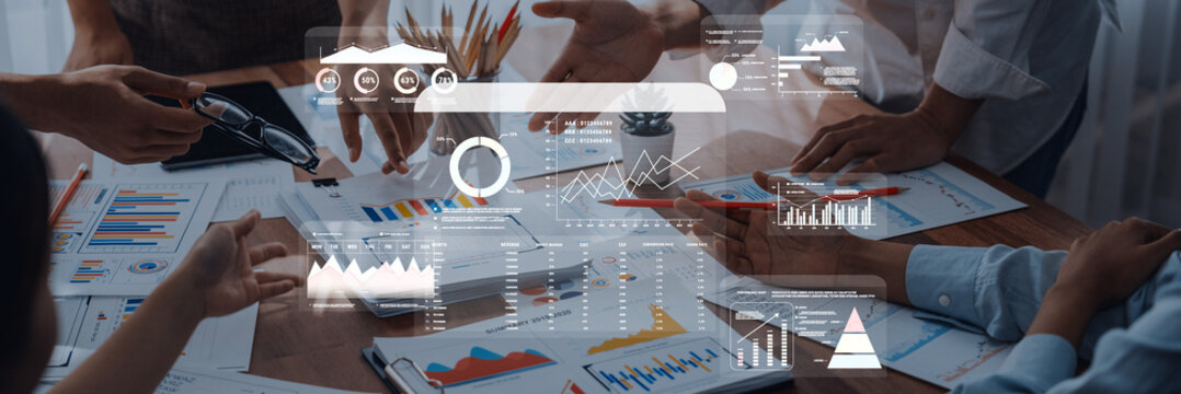 A group of professionals engaged in a business meeting analyzing data visualizations and graphs for strategic planning and effective decision making in a modern workplace. Trope
