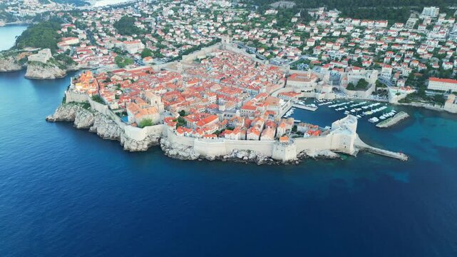 Dubrovnik Old Town, Croatia. Slow ariel pan around the walls and city, showing red roofs, castle and church. Shot at 60 fps on a DJI Mini 3 Pro in D-Log Film Colorgraded