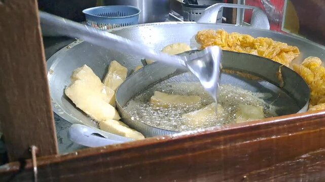 Indonesian street vendor making Tahu Tek Telur. Process includes whisking egg, frying omelette and tofu, cutting lontong with scissors, and making peanut petis sauce. Authentic Surabaya street food.