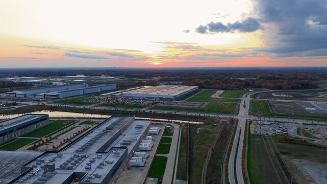 Aerial view of massive data centers and industrial park warehouses at sunset