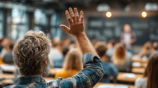 Student raising hand in lecture hall at university