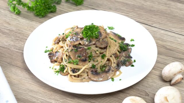 Spaghetti with champignon mushrooms and cream cheese on a wooden table