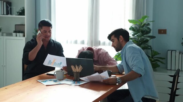 Professional businessman waking tired partner fall asleep or taking a nap while project manager calling phone and talking about marketing campaign. worker using phone to talk to investor. Convocation.