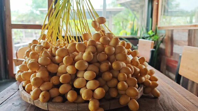 Bountiful Fresh Yellow Date Palm Bunch on Wooden Table.